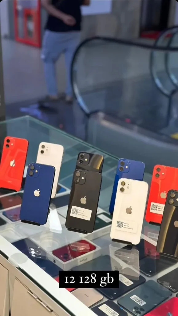 Multiple iPhone 12 models in various colours, including blue, black, white, and red.